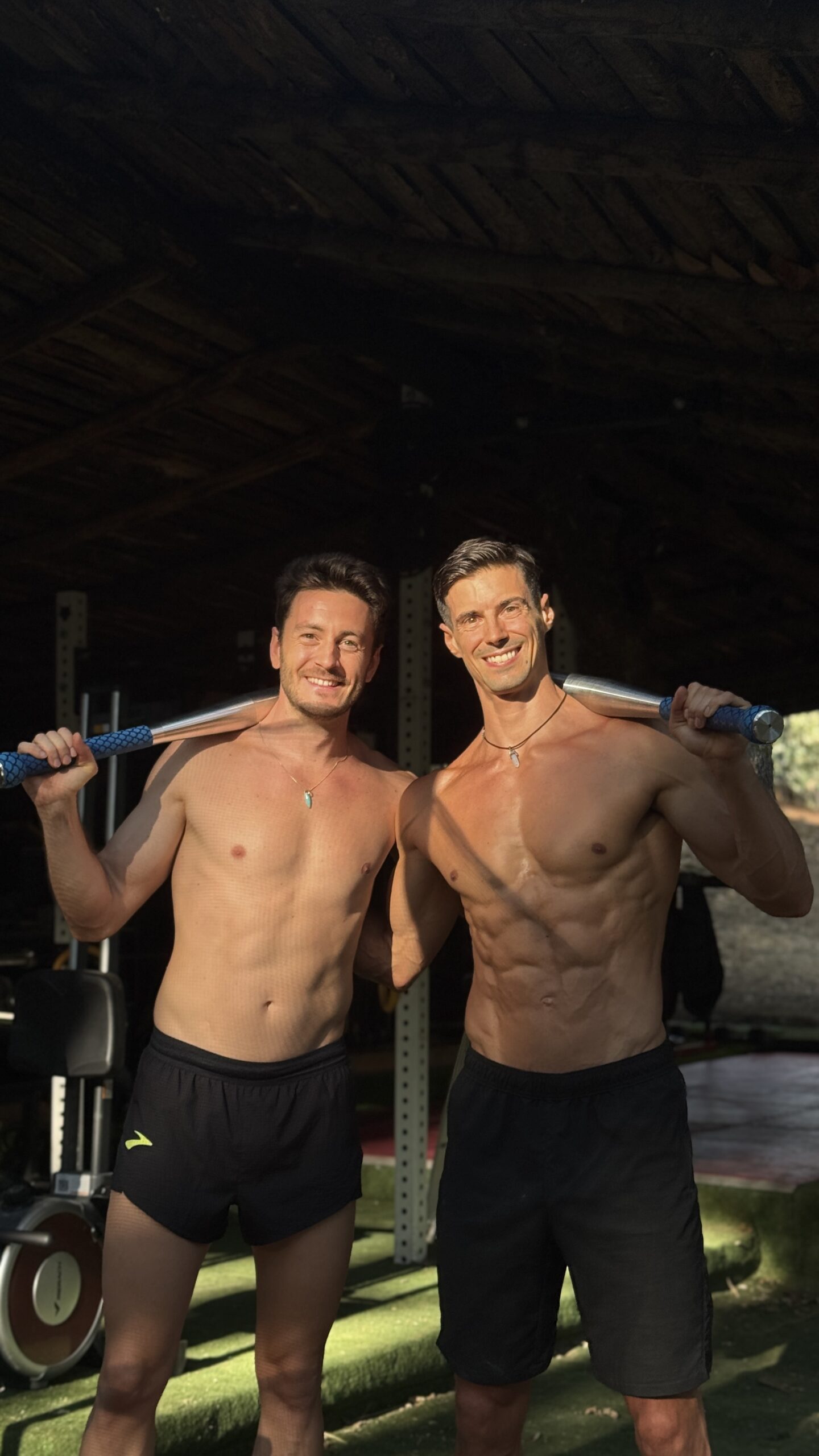 Dos deportistas sostienen steel clubs azules durante un entrenamiento